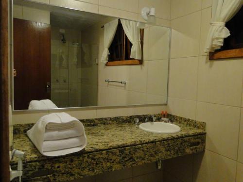 a bathroom with a sink and a mirror at Pousada Jardim Comary in Teresópolis