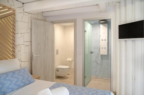 a bedroom with a bed and a shower and a toilet at Nine - Cozy Rooms in Chania