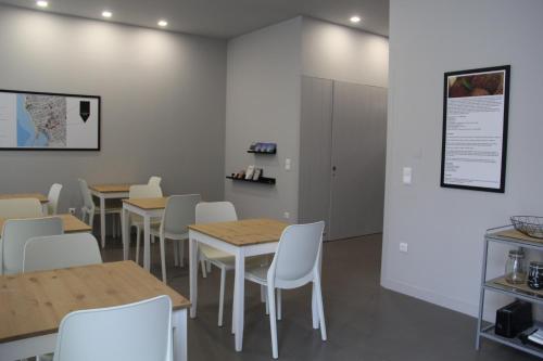 a dining room with tables and white chairs at StayInn City - Póvoa de Varzim in Póvoa de Varzim