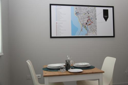 a table with white chairs and a picture on the wall at StayInn City - Póvoa de Varzim in Póvoa de Varzim