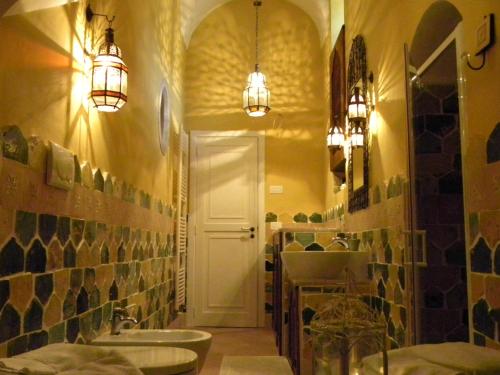 a bathroom with a sink and a mirror and lights at Villa in Gargano - VILLA BASSO in Monte SantʼAngelo