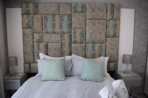 een slaapkamer met een groot wit bed en 2 nachtkastjes bij Aya Luxury Apartment 84 in Durban