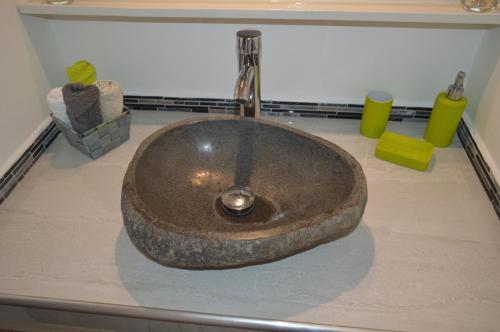 a bathroom sink with a large stone sink at Maison Petit Paradis in Basse-Terre