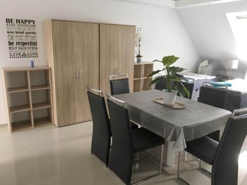 a dining room with a table and chairs and a kitchen at Pension / Zimmervermietung Wasbek in Wasbek