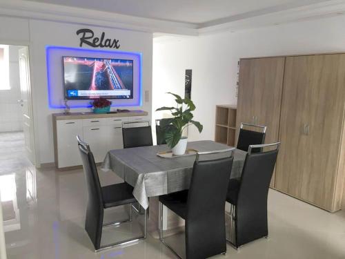 een eetkamer met een tafel en stoelen en een televisie bij Pension / Zimmervermietung Wasbek in Wasbek
