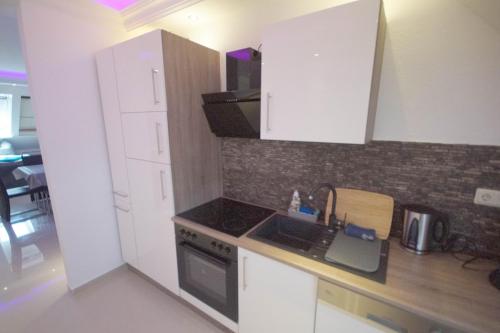 a kitchen with white cabinets and a stove top oven at Pension / Zimmervermietung Wasbek in Wasbek