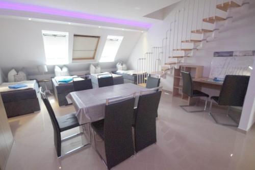a dining room with a table and chairs and a staircase at Pension / Zimmervermietung Wasbek in Wasbek