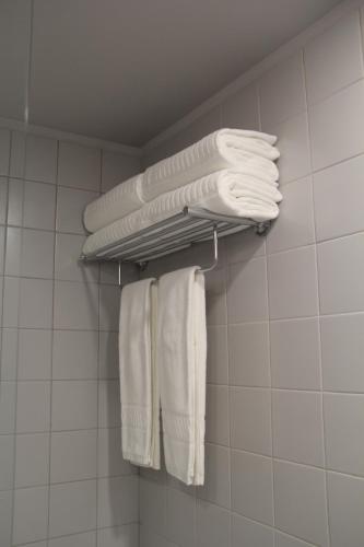 a group of white towels hanging on a rack in a bathroom at StayInn City - Póvoa de Varzim in Póvoa de Varzim