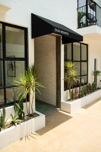 a building with a black awning and some plants at Residencia Tropical Don Bonito in Sayulita