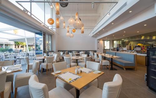 a restaurant with tables and chairs and a counter at Protaras Plaza Hotel in Protaras