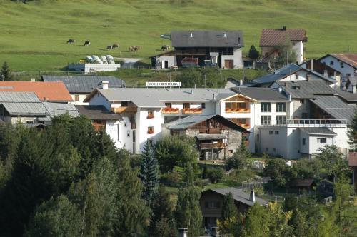 a group of houses on a hill with horses in a field at Hotel Crusch Alba Sta Maria in Sta Maria Val Müstair