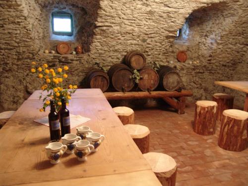 a wooden table with wine bottles and cups and a bench at Hotel Crusch Alba Sta Maria in Sta Maria Val Müstair