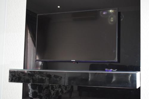 a large black tv sitting on top of a shelf at Aya Luxury Apartment 84 in Durban