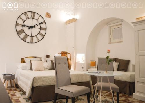 una camera con due letti e un orologio a muro di Sangiuliano a Laterza