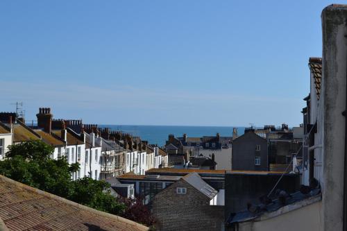 a city with houses and the ocean in the background at Kemp Town Sea View Balcony Apartment in Brighton & Hove