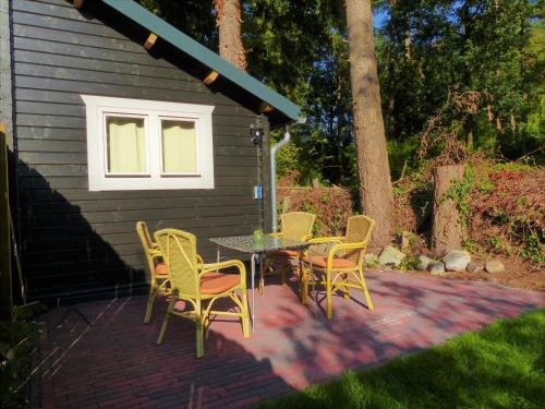 a patio with a table and chairs and a building at Herberg De Eexter Os in Eext