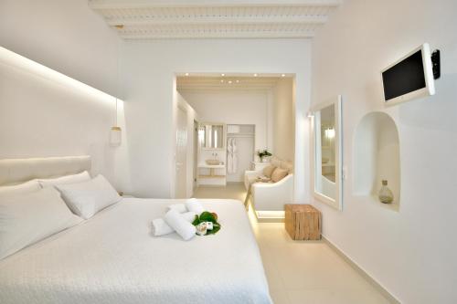 una camera da letto bianca con un orsacchiotto su un letto di Marietta's a Mykonos Città
