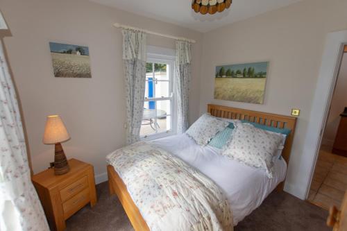 een slaapkamer met een bed en een raam bij Pellipar Gatelodge in Bovevagh