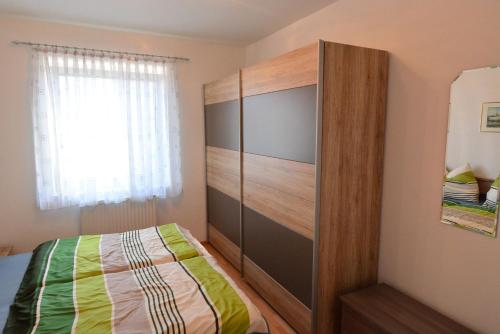 1 dormitorio con 1 cama y un gran armario de madera en Appartement Gombotz en Halbenrain