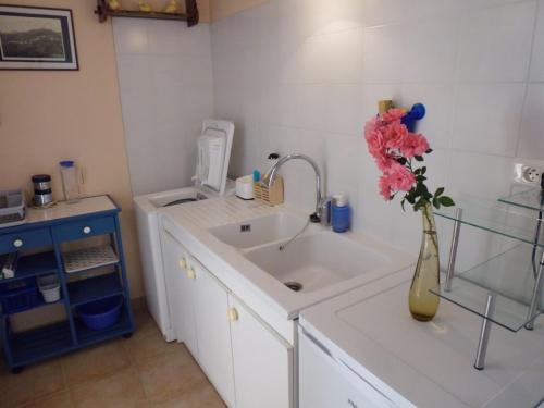 ein Badezimmer mit einem Waschbecken und einer Vase mit Blumen darin in der Unterkunft Villa mit grosser Sommerküche und Pool, 8 Minuten zum Sandstrand Cap Sud in LʼArena