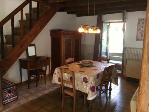 une salle à manger avec une table et des chaises et un escalier dans l'établissement La petite maison, à Fromental