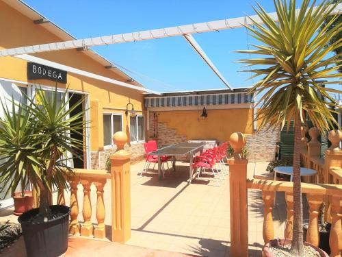 a patio with palm trees and a table and chairs at Posada Chloe Santiago in Santiago de la Ribera