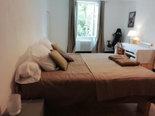 une chambre avec un lit avec des oreillers dessus dans l'établissement La maison Bleue, à Céreste