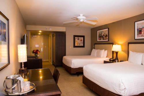 a hotel room with two beds and a table at Isle Casino Hotel Bettendorf in Bettendorf