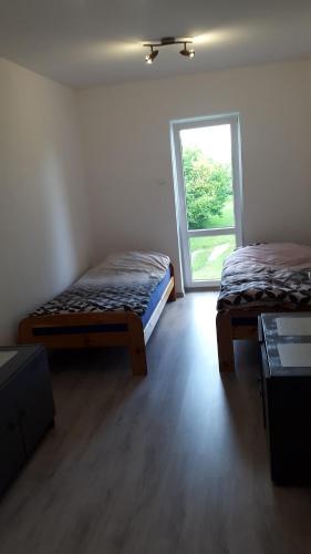 2 Betten in einem Zimmer mit Fenster in der Unterkunft Mazury apartament in Woźnice