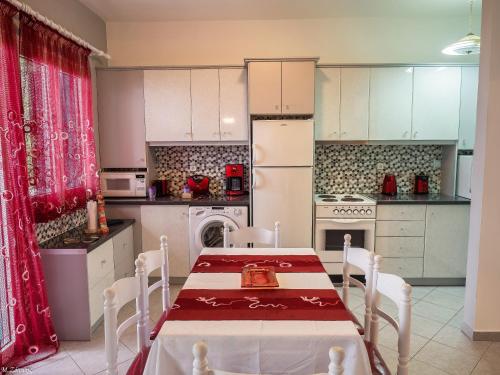 uma cozinha com uma mesa e um frigorífico branco em Xenia Apartment em Kokkari