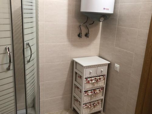 a bathroom with a shower stall with a white cabinet at Apartamenti Ely in Pomorie