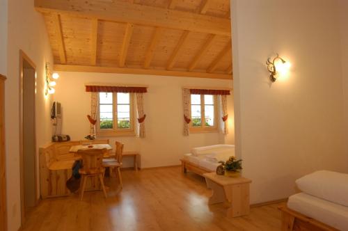 a living room with a table and a bed at Hotel Crusch Alba Sta Maria in Sta Maria Val Müstair