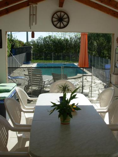 un patio avec une table et des chaises et une piscine dans l'établissement Villa mit grosser Sommerküche und Pool, 8 Minuten zum Sandstrand Cap Sud, à LʼArena