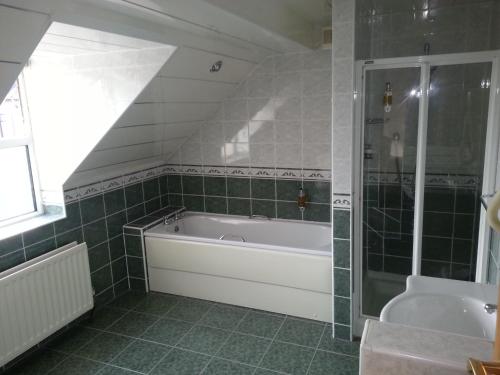 a bathroom with a bath tub and a shower at The Windsor Hotel in Whitley Bay