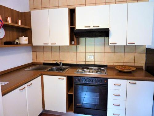 a kitchen with white cabinets and a sink and a stove at Andromeda in Stresa