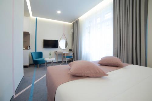 a bedroom with a bed with two pillows and a desk at City Nest Modern & Cozy Suites in Belgrade