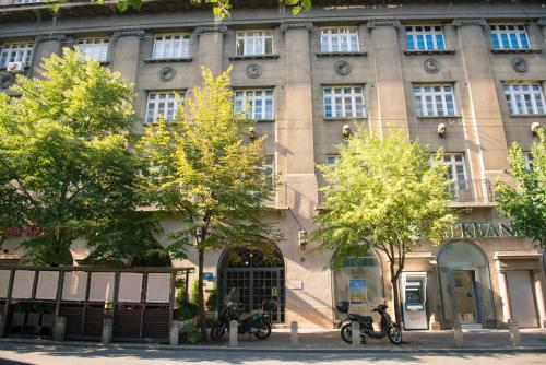 a large building with trees in front of it at City Nest Modern & Cozy Suites in Belgrade