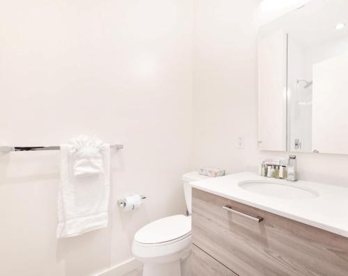 a white bathroom with a toilet and a sink at Global Luxury Suites Downtown Boston in Boston
