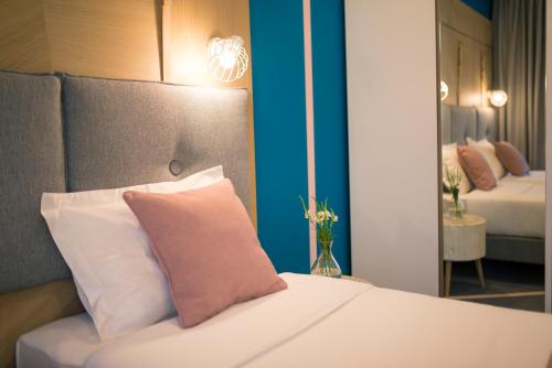 a hotel room with a bed with a pink pillow at City Nest Modern & Cozy Suites in Belgrade