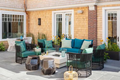 a patio with a blue couch and chairs at The Sydney, The Edgartown Collection in Edgartown