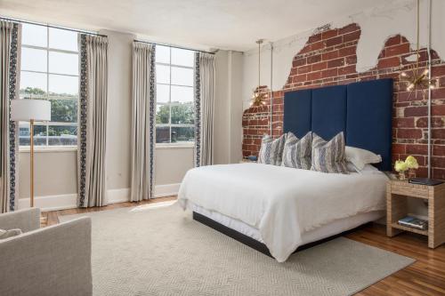 a bedroom with a large bed and a brick wall at The Stricklin Hotel- Florence in Florence