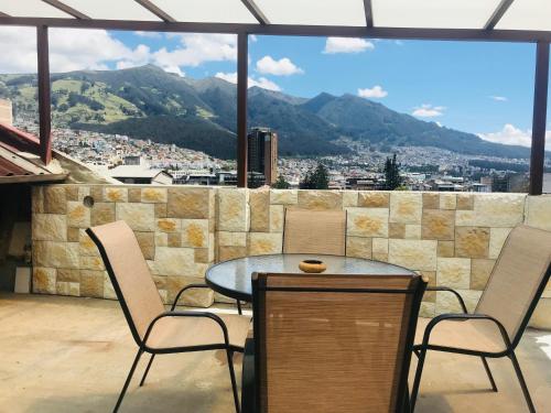 a table and chairs on a balcony with a view at Hostel Revolution Quito in Quito