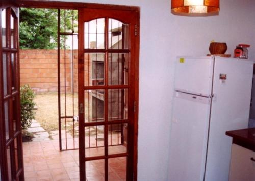 cocina con nevera y puerta a un patio en Ramita-Costa Azul en San Bernardo