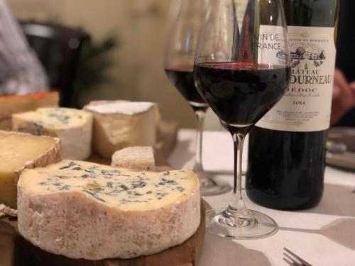 a table with two glasses of wine and cheese at Domaine La Reveille in Dore-lʼÉglise