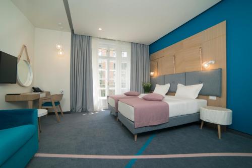 a hotel room with a bed and a desk at City Nest Modern & Cozy Suites in Belgrade