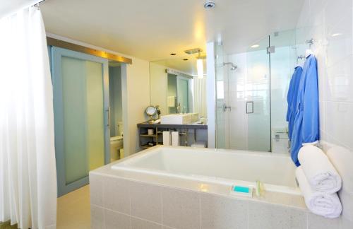 a white bathroom with a tub and a shower at Tower 23 Hotel in San Diego