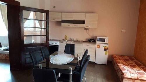 a kitchen with a table and chairs in a room at Korona Panzió in Balog nad Ipľom