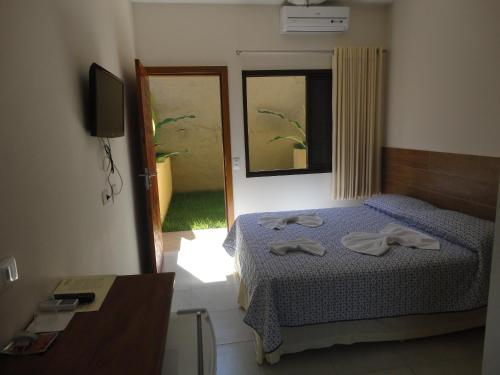 a bedroom with a bed with two towels on it at Pousada Samburá in Barra do Una