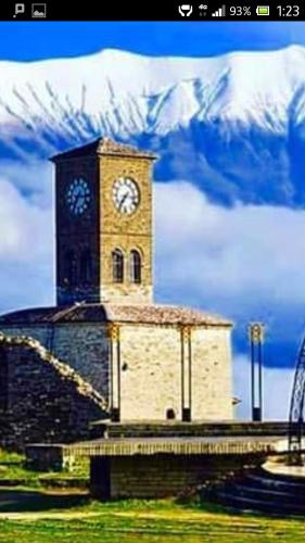 a building with a clock tower on top of it at Camping late in Gjirokastër