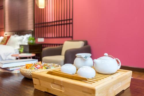a table with two white vases on a wooden tray at Chongqing Ouranjian Lake View Guesthouse in Chongqing